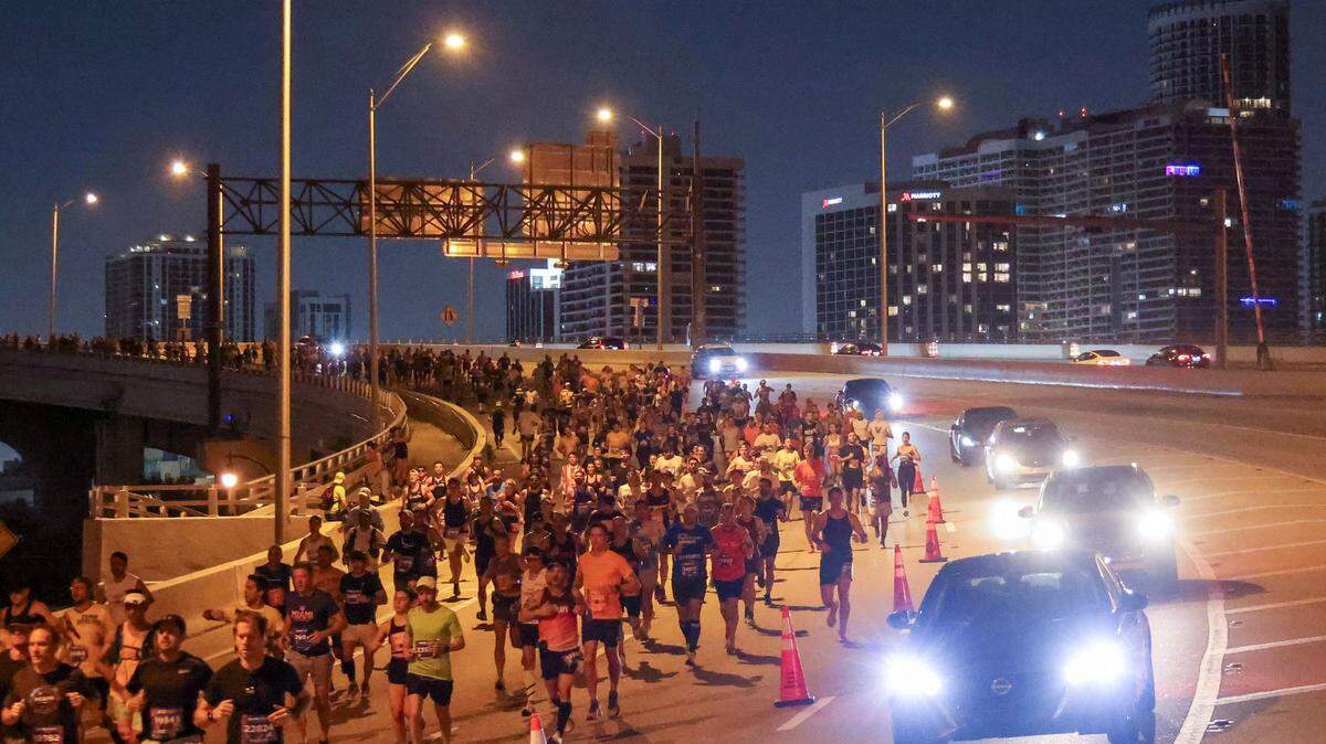 Runners descend MacArthur Causeway while sharing the road with vehicles during the Life Time Miami Marathon on Sunday, January 28, 2024 in Miami, Florida