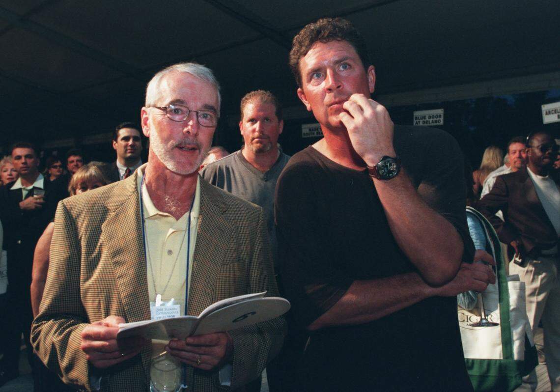 In 2001, Bob Dickinson, president of Carnival Cruise, and Dan Marino of the Miami Dolphins listen carefully as bids are made during the 2001 Florida Extravaganza at the FIU North Campus. The bids were for wine, travel and dinners.