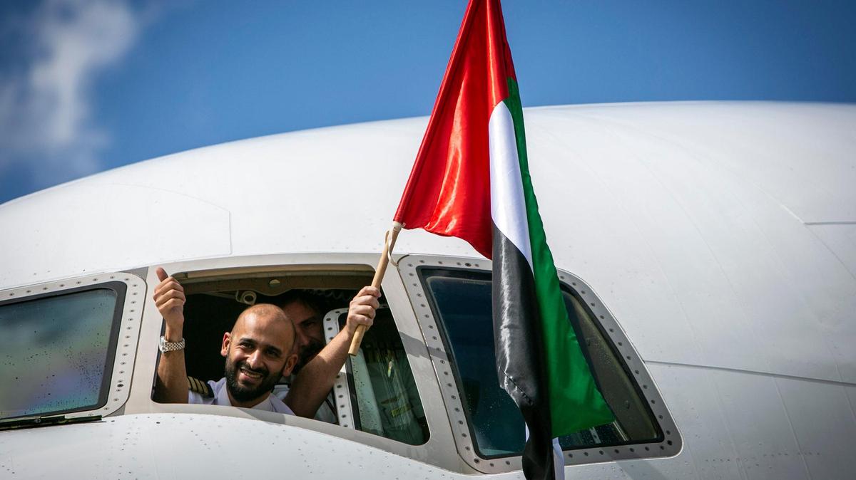 The crew of the first Emirates Airline flight to land in Miami waved U.S. and United Arab Emirates flags after arriving at the gate following a water canon salute at Miami International Airport on Thursday, July 22, 2021.