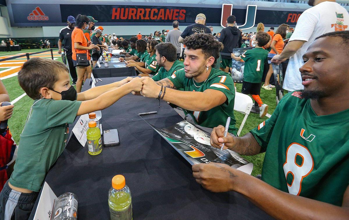 Miami Hurricanes wide receiver Xavier Restrepo (7) fist pumps Gabriel Bertot, 5, during CanesFest at Carol Soffer Indoor Practice Facility at the University of Miami in Coral Gables on Saturday, August 6, 2022.