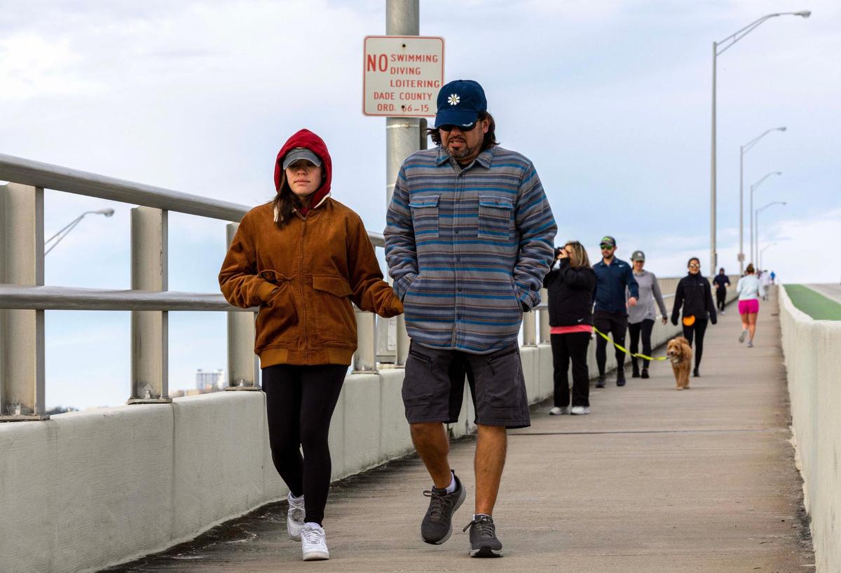 People walk on the William Powell Bridge along the Rickenbacker Causeway in Key Biscayne, Florida, on a chilly Saturday, Dec. 24, 2022.