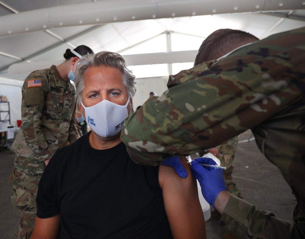 Patricio D’Salvio, 50, a Miami communications specialist from Argentina, sits calmly while getting his COVID-19 vaccination by Department of Defense medical personnel on Monday at the MDC North vaccine site, run by FEMA. On Monday, people 50 and older became eligible for the vaccine statewide.