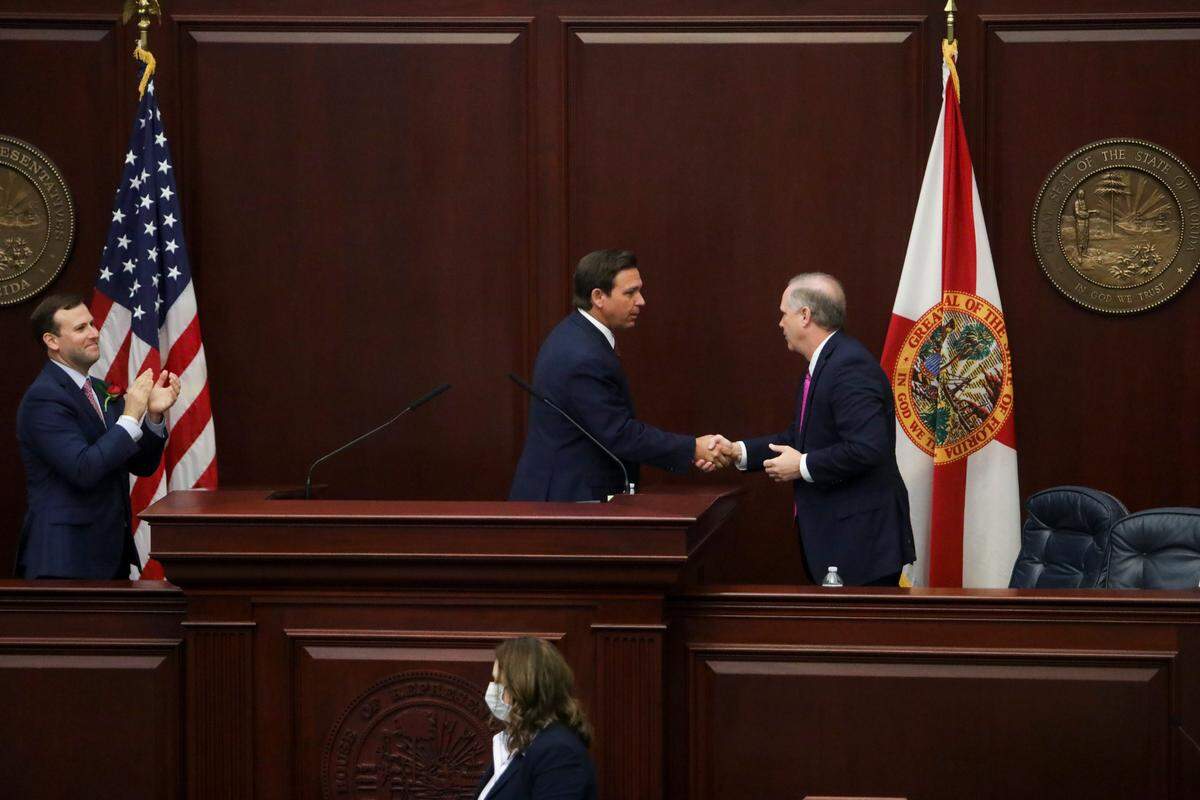 House Speaker Chris Sprowls, R- Palm Harbor, claps as Gov. Ron DeSantis shakes hands with Senate President Wilton Simpson, R-Spring Hill, following his address during the joint session of the Florida Legislature at the Capitol in Tallahassee on Tuesday, March 2, 2021.