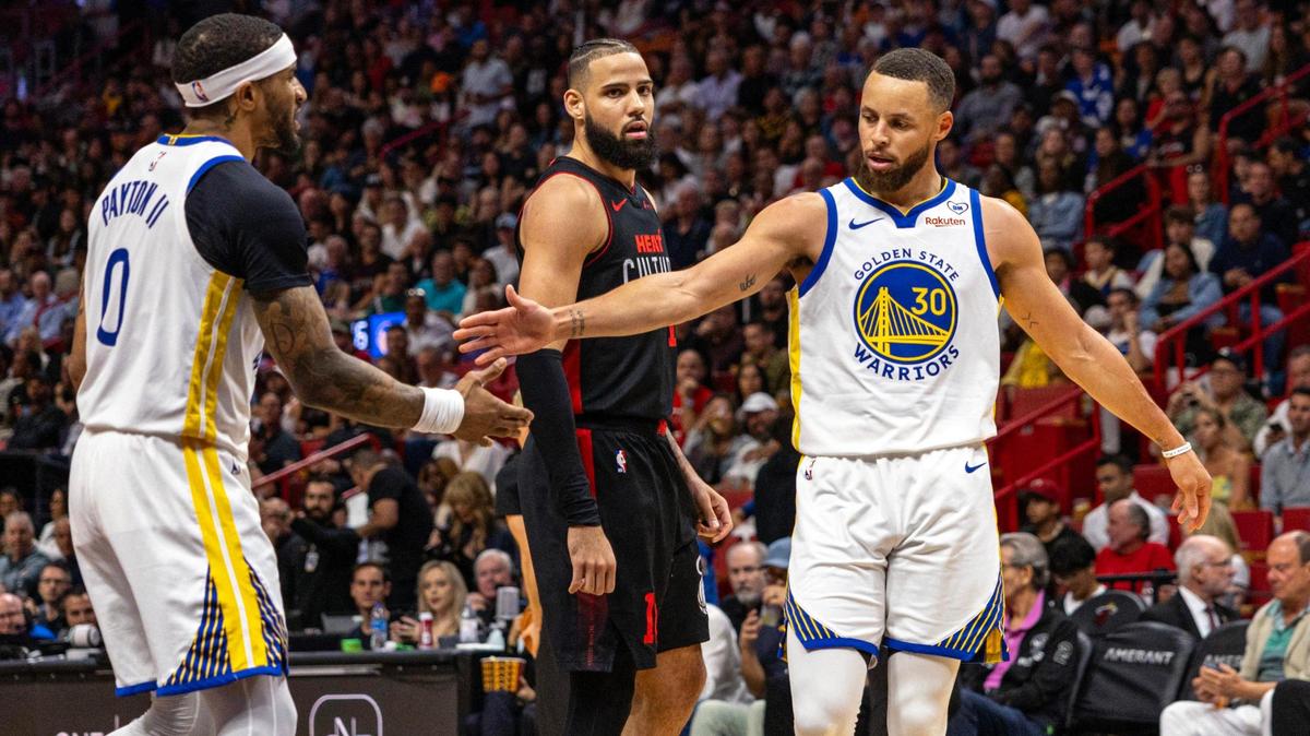 Golden State Warriors guard Stephen Curry (30) reacts with teammate guard Gary Payton II (0) during the first half of an NBA game against the Miami Heat at Kaseya Center in Miami, Florida, on Tuesday, March 26, 2024.
