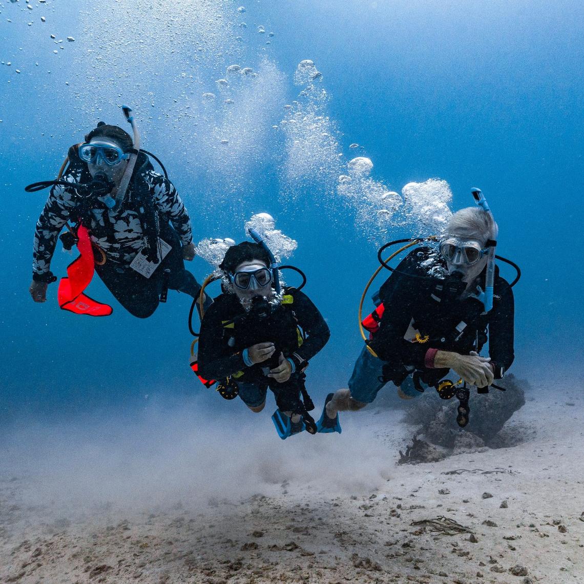 Master Diver Matteo Miller, 12, center, his father Paul Miller, right, swim alongside dive instructor Gabi Bello, left, during an ocean dive session on Friday, August 9, 2024, in Key Biscayne, Fla. Miller received the Master Diver certification after completing his Rescue diver certification.