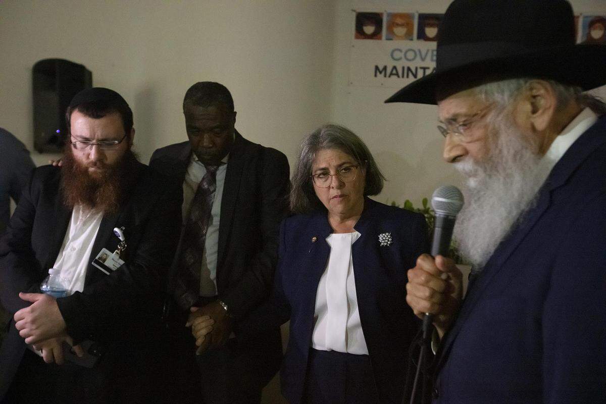 Rabbi Sholom Lipskar, right, spiritual leader of The Shul of Bal Harbour, prays during the search-and-rescue operation after the partial collapse of the Champlain Towers South in Surfside on Thursday, June 24, 2021. Rabbi Mendy Levy, the Chabad Chaplaincy Network Chaplain at Mount Sinai Medical Center, and Daniella Levine Cava, mayor of Miami-Dade County, join him.