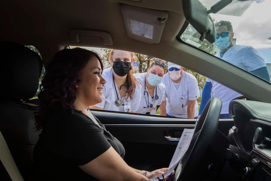 In the car Joan Rivera and (L to R) Helena Cabrera, Abigail Rivera , Jamie Simmons from South Florida College of Nursing at the “Stay Well Community Vaccine Event” at the Sweet Home Missionary Baptist Church, in Cutler Bay, on Saturday February 26, 2022.