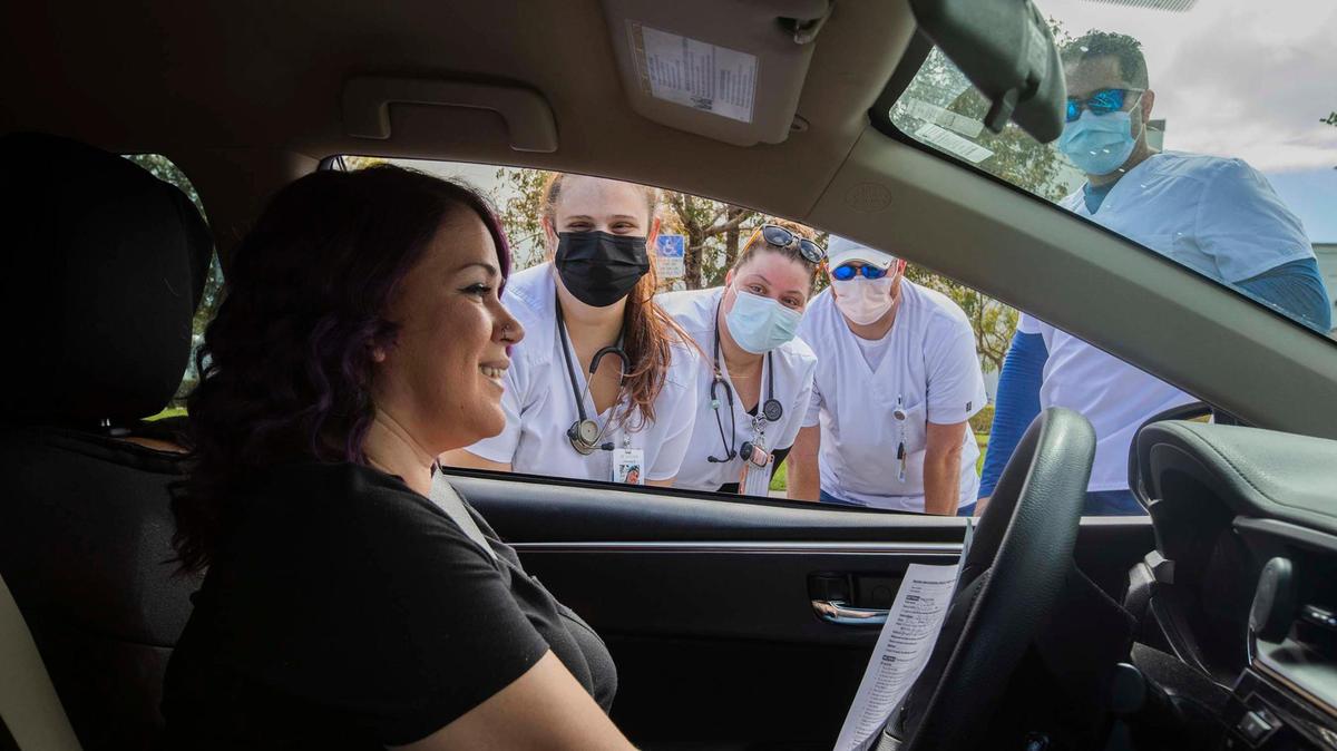 In the car Joan Rivera and (L to R) Helena Cabrera, Abigail Rivera , Jamie Simmons from South Florida College of Nursing at the “Stay Well Community Vaccine Event” at the Sweet Home Missionary Baptist Church, in Cutler Bay, on Saturday February 26, 2022.