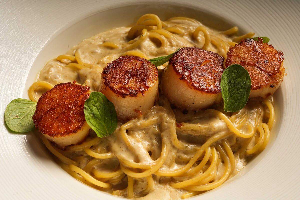 Seared scallops over spaghetti with walnut sauce at Francesco Peruvian restaurant in Coral Gables.