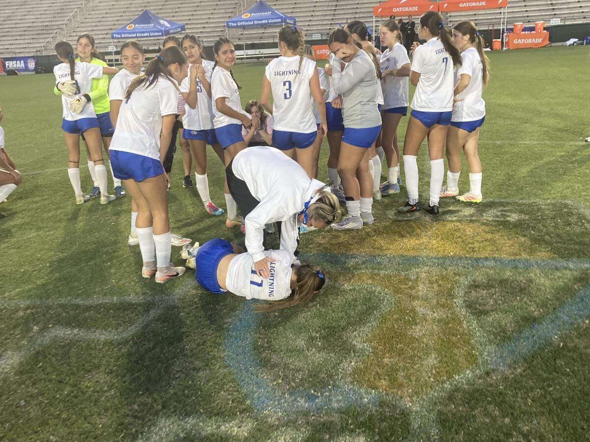 Cypress Bay girls soccer coach Kate Dwyer consoles one of her players on the field after losing the Class 7A state final to Lake Mary in a penalty kick shootout on Wednesday at Spec Martin Stadium in DeLand, Fla.