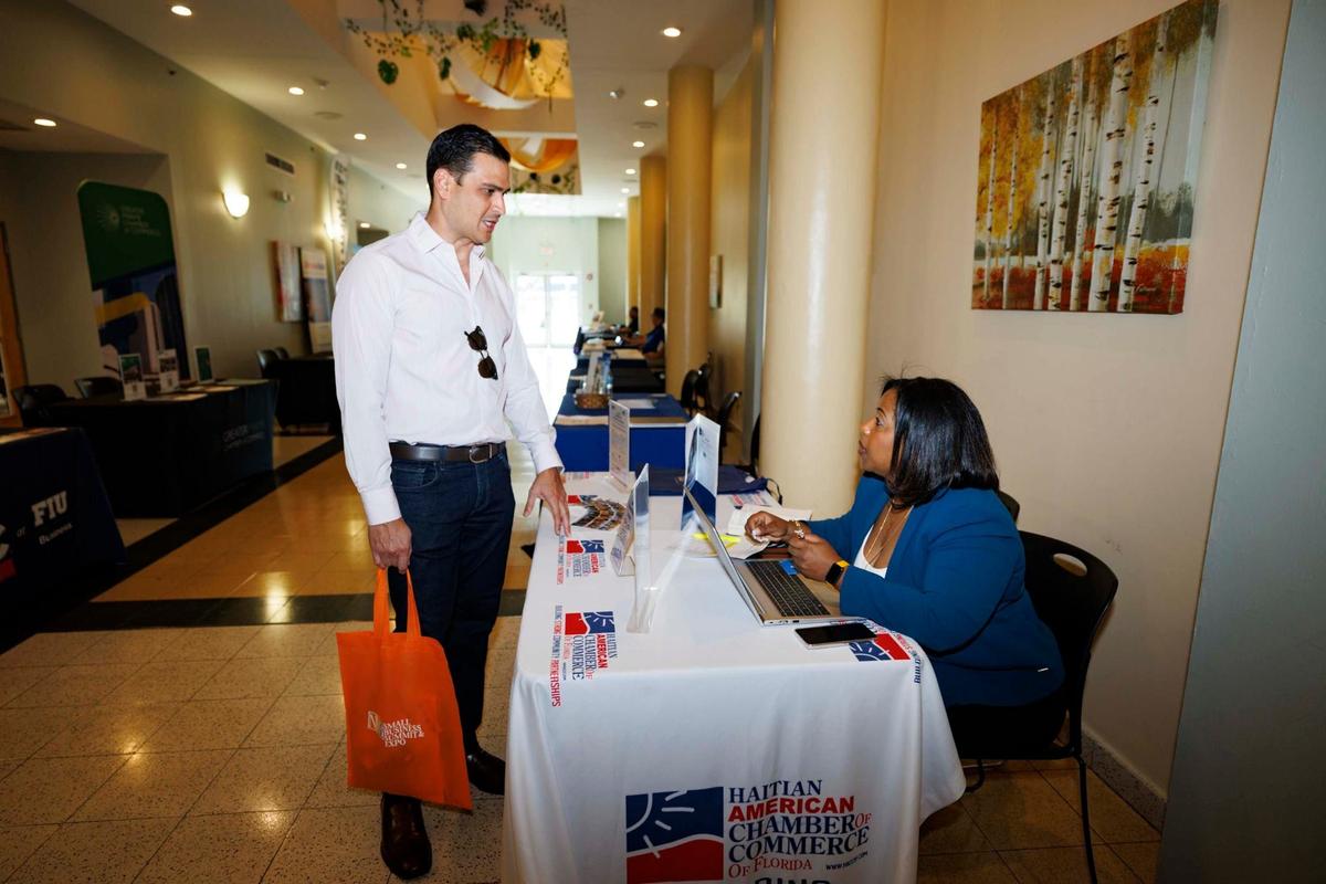 Erika Rosenthal from the Haitian American Chamber of Commerce, right, speaks to a business owner during the North Miami Beach Small Business Expo on Wednesday, May 8, 2024, at North Miami Beach City Hall. The Chamber helps Miami-based businesses with marketing, leadership, finance and operation.
