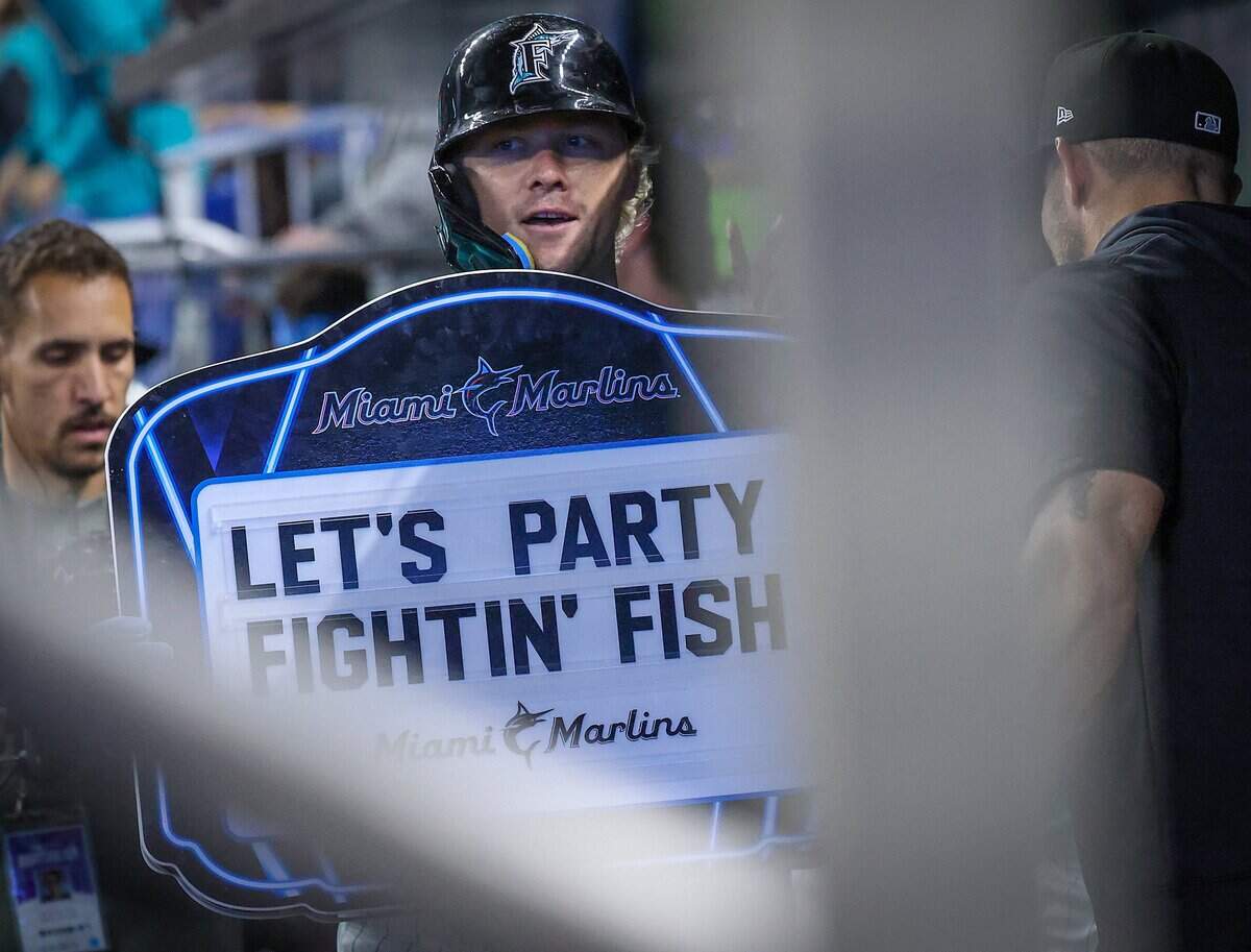 Miami Marlins' Kyle Stowers celebrates with teammates in the dugout, holding Marlins' homer signs, after hitting a home run during bottom of the second inning against the San Francisco Giants on Father's Day, Sunday, June 21, 2026, at loanDepot Park in Miami.