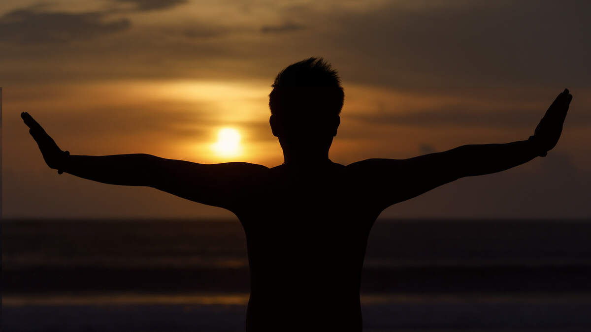 A man does yoga on the beach as the sun sets in the Kerobokan district on Indonesia’s resort island of Bali on December 31, 2023.