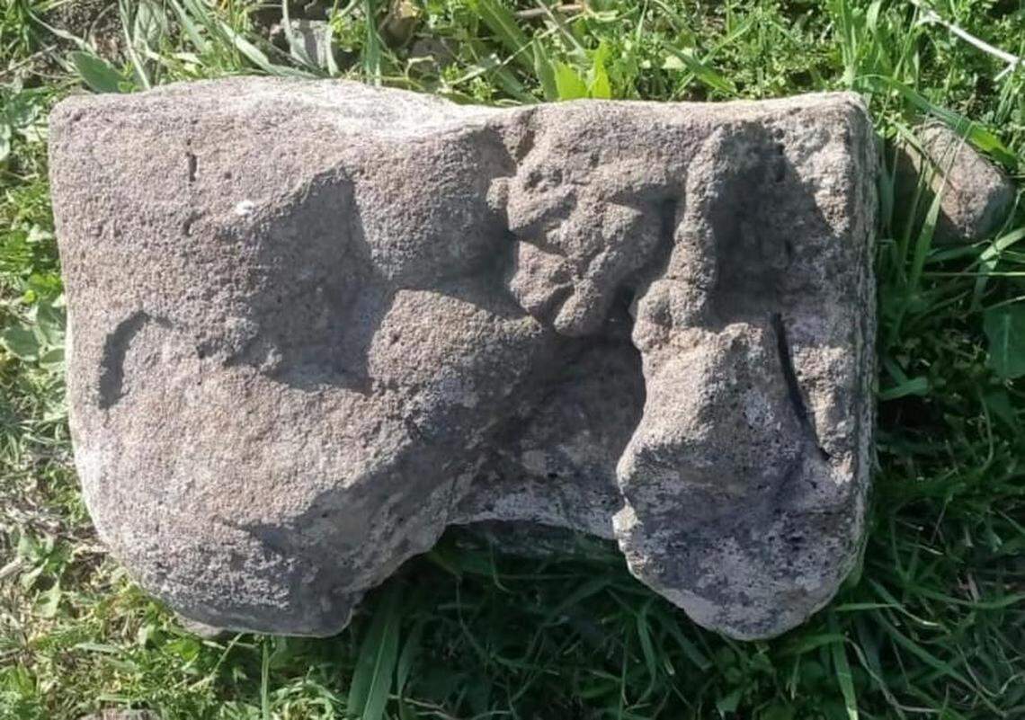 The lioness statue sitting on the grass.