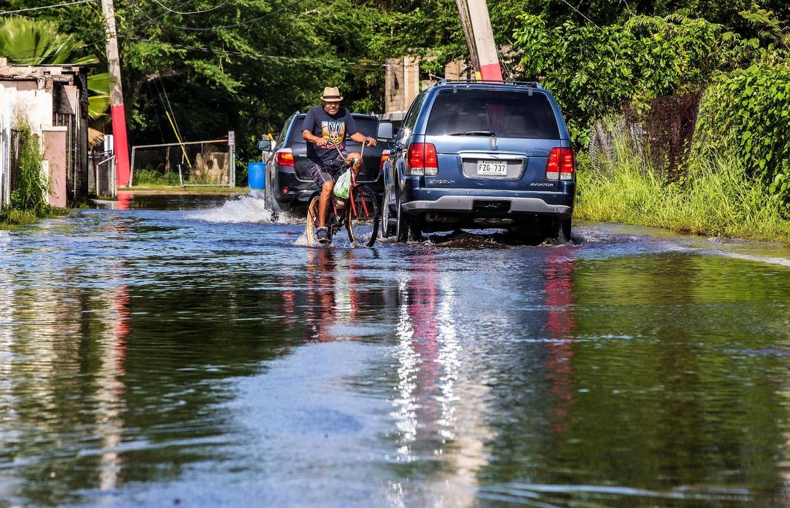 Roberto Pines Matos bikes through a flooded street caused by Hurricane Fiona’s heavy rain that flooded the Miñi Miñi neighborhood in the town of Loíza on the northeastern coast of Puerto Rico as the hurricane passed by the island on Monday September 18, on Wednesday, September 21, 2022.