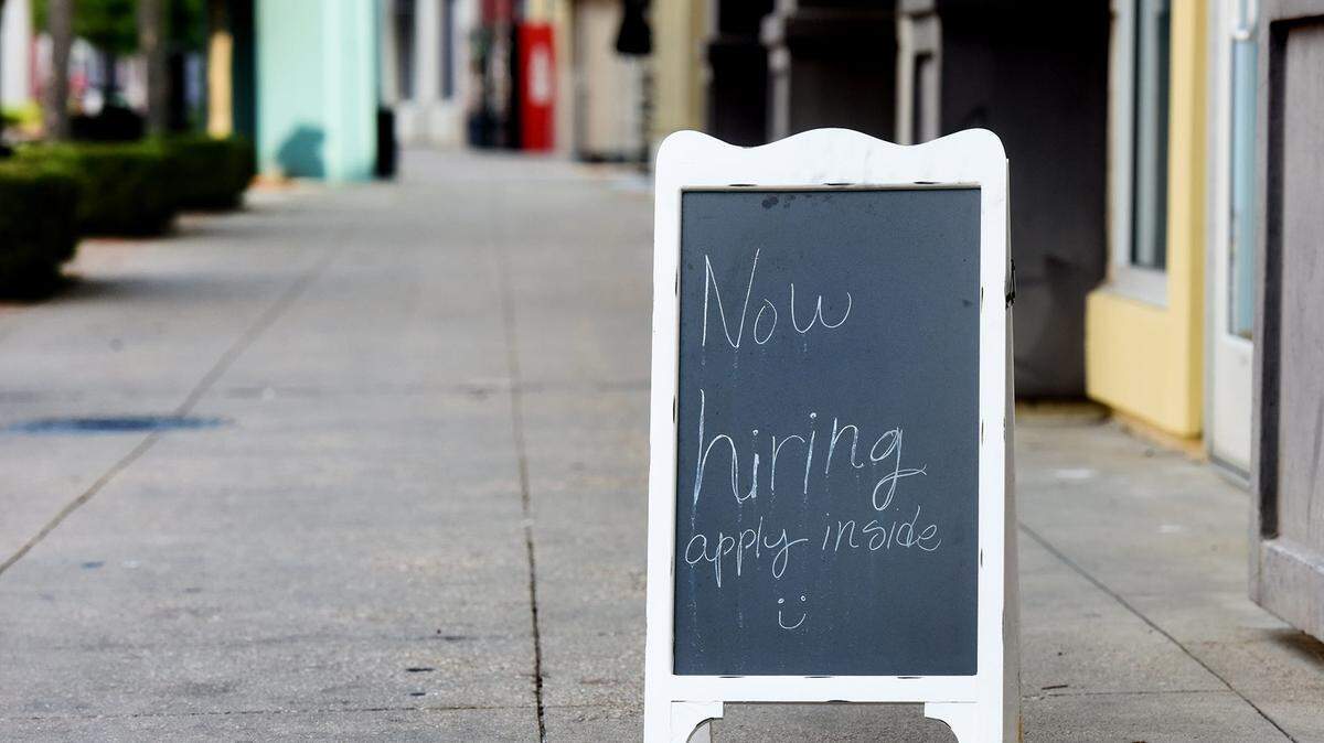 A “Now Hiring” sign.