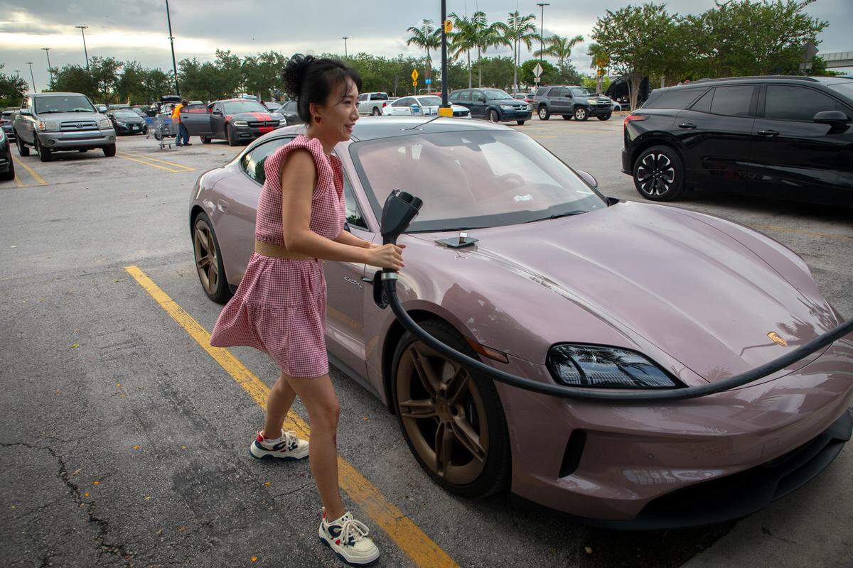 A Porsche Taycan owner plugs into an electric vehicle charging port in the Walmart parking lot in Hialeah last August