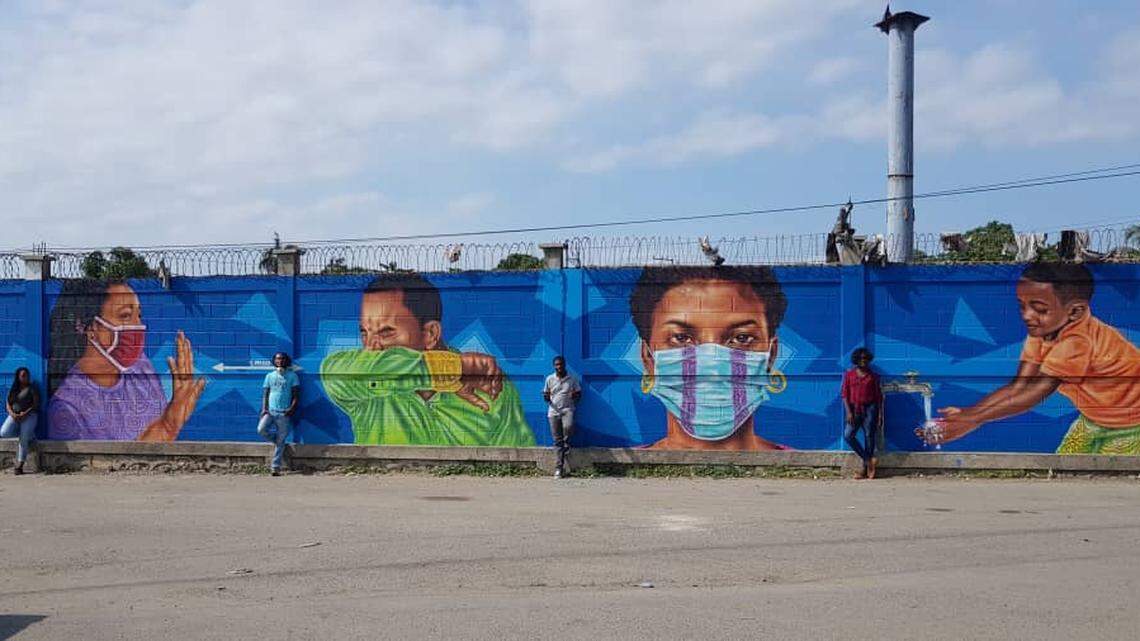 Haitians fleeing the Dominican Republic because of COVID-19 and arriving in Ouanaminthe, just outside of Cap-Haitien, are greeted by the newly painted mural reminding them to wear a mask and cover their faces when they sneeze.