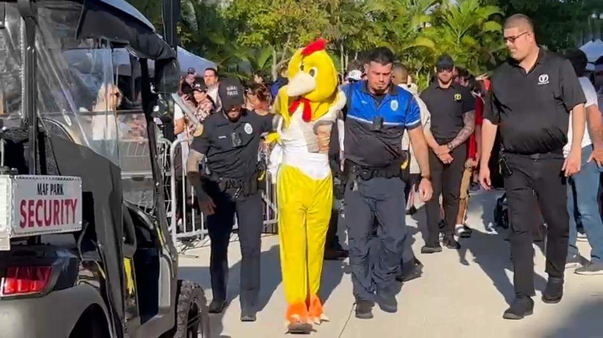 La Policía de Miami retira a un manifestante disfrazado de pollo en la inauguración el sábado del Dogs & Cats Walkway, en el Museum Park de Miami.