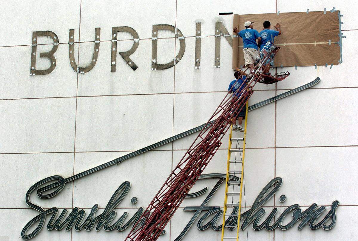 In 2005, workers tend to the sign of the department store just off Lincoln Road on meridian Avenue.