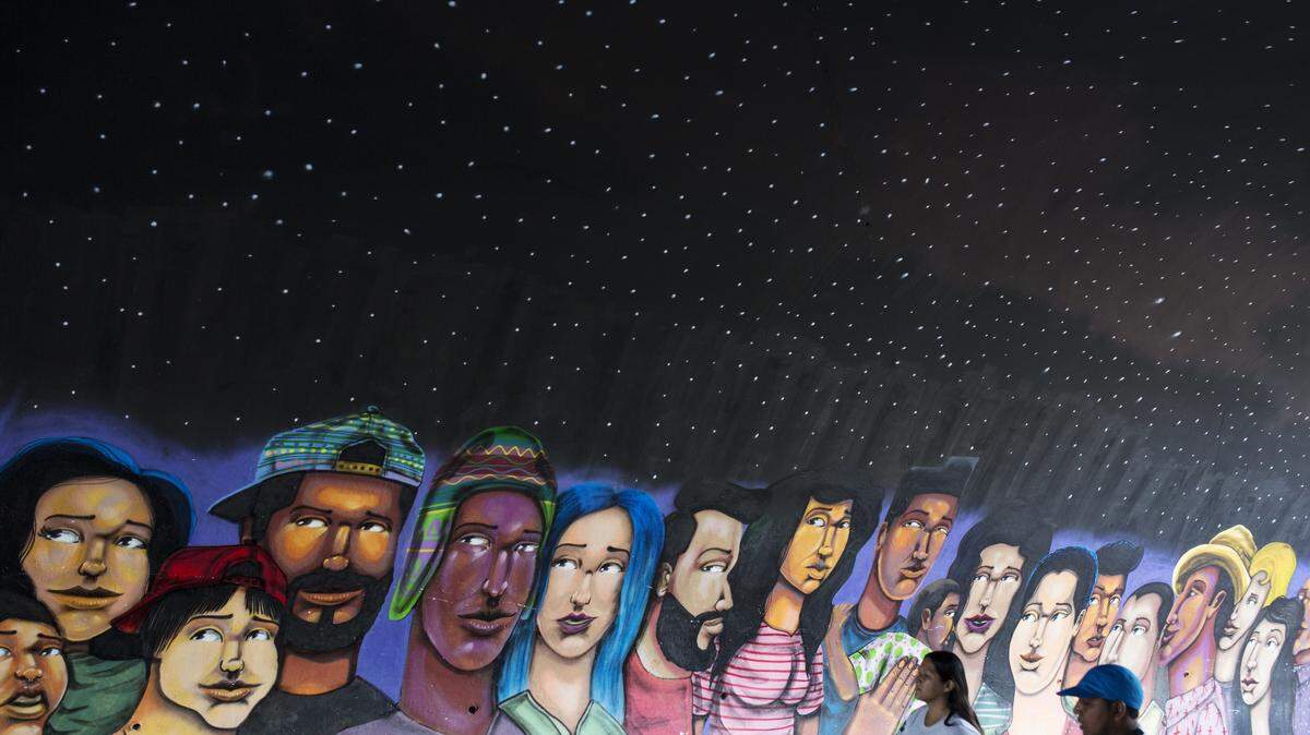 People walk past a mural in Lima, Peru, Thursday, March 22, 2018.
