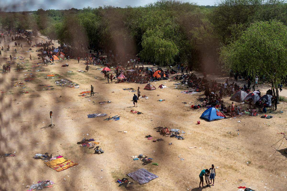 Migrants seeking asylum in the U.S. rest near the International Bridge between Mexico and the U.S. as they wait to be processed, in Del Rio, Texas, U.S., September 16, 2021. REUTERS/Go Nakamura - RC24RP9AC6G3