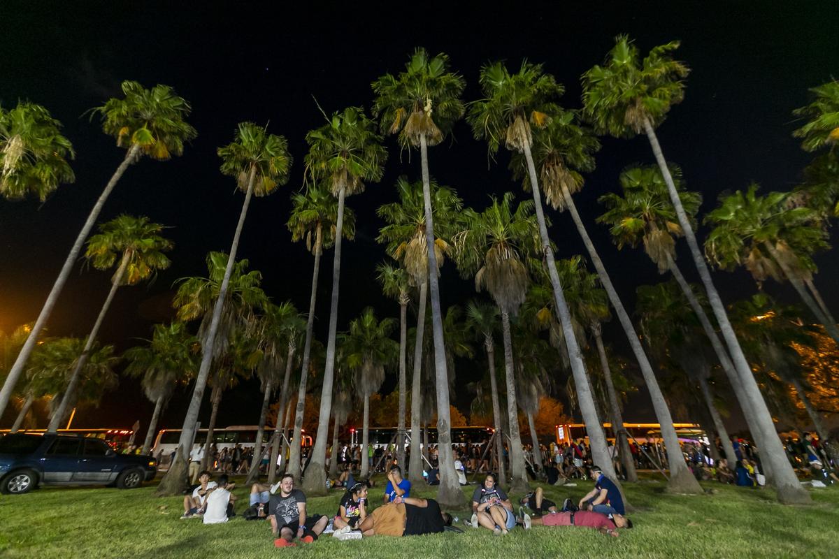 A group of friends from Houston, Texas rest from waiting in long lines for a shuttle bus after leaving the 2019 Ultra Music Festival in Virginia Key, Florida on Saturday, March 30, 2019.