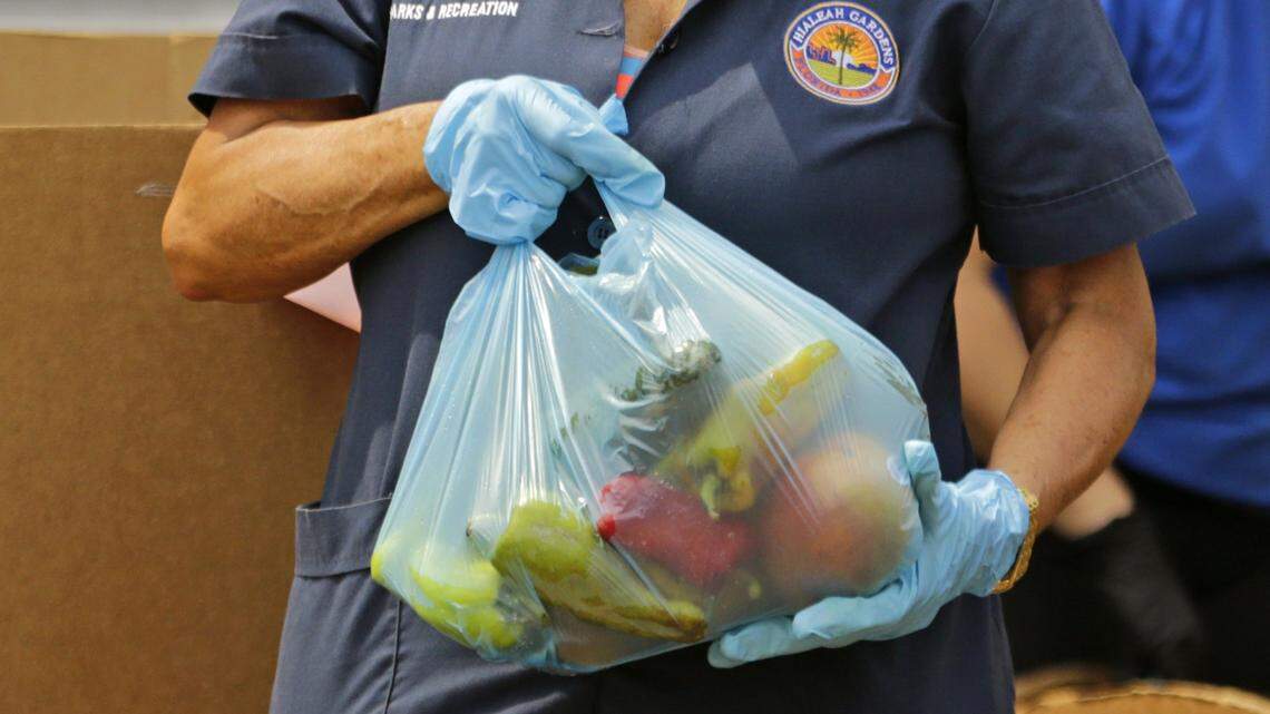 Hialeah Gardens Department of Parks & Recreation employees load up food and vegetables to hundreds of cars lined up for hours early at Mater Academy on Thursday, April 16, 2020 in Hialeah Gardens. The food giveaway was coordinated by Hialeah Gardens, which teamed up with Feeding South Florida Miami-Dade.