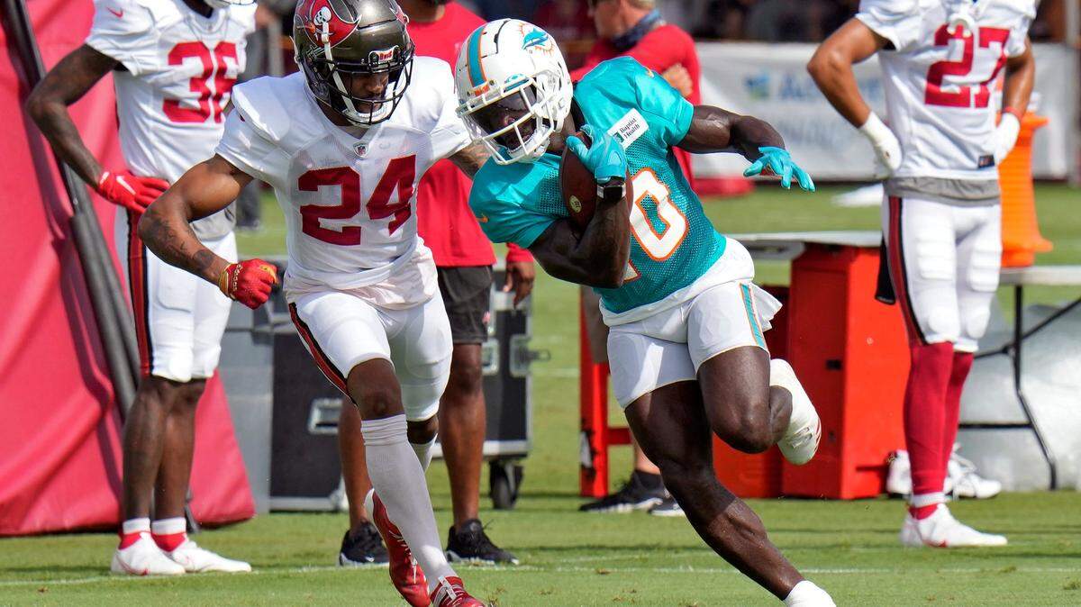 El wide receiver de los Dolphins, Tyreek Hill (10), hace una atrapada frente al CB de os Buccaneers, Carleton Davis III (24), durante una práctica del campamento de entrenamiento de la NFL el miércoles, 10 de agosto de 2022, en Tampa, Florida.
