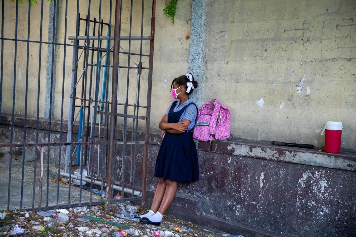 A student waits for her turn to enter the Lycee Marie Jeanne school on the first day back to school since the COVID-19 pandemic in Port-au-Prince, Haiti.