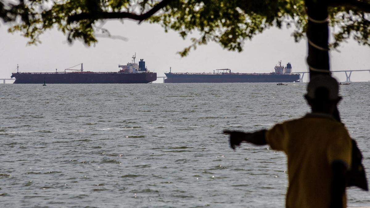 A man watches two crude oil tankers remaining anchored on Lake Maracaibo, near Maracaibo, Zulia state, Venezuela on Dec. 17, 2025. On Dec. 16, President Donald Trump ordered a "total and complete blockade" of sanctioned oil tankers Venezuela has been using to bypass a six-year-old US oil embargo. 