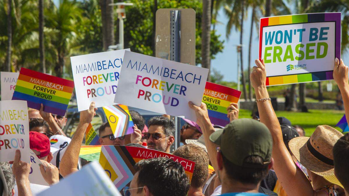 Demonstrators carrying rainbow flags and signs reading ‘Miami Beach Forever Proud’ and ‘Won’t Be Erased’ march during the Forever Proud March on Ocean Drive in Miami Beach on Aug. 31, 2025, held after state officials ordered the removal of the city’s LGBTQ Pride crosswalk.
