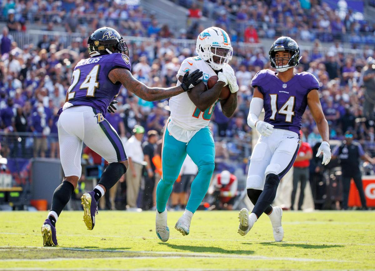 Miami Dolphins wide receiver Tyreek Hill (10) scores a touchdown against the defense of Baltimore Ravens cornerback Marcus Peters (24) and safety Kyle Hamilton (14) during fourth quarter of an NFL football game at M&T Bank Stadium on Sunday, September 18, 2022 in Baltimore, MD.