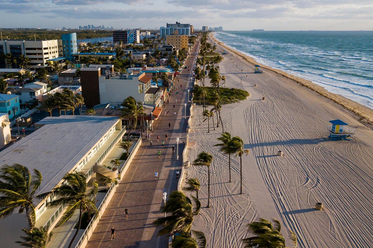 People make their way down the Hollywood Beach Broadwalk after it was reopened on Wednesday, May 13, 2020. The Broadwalk, which was closed in March because of the coronavirus, will now be open from 6 a.m. to 9 a.m. daily.