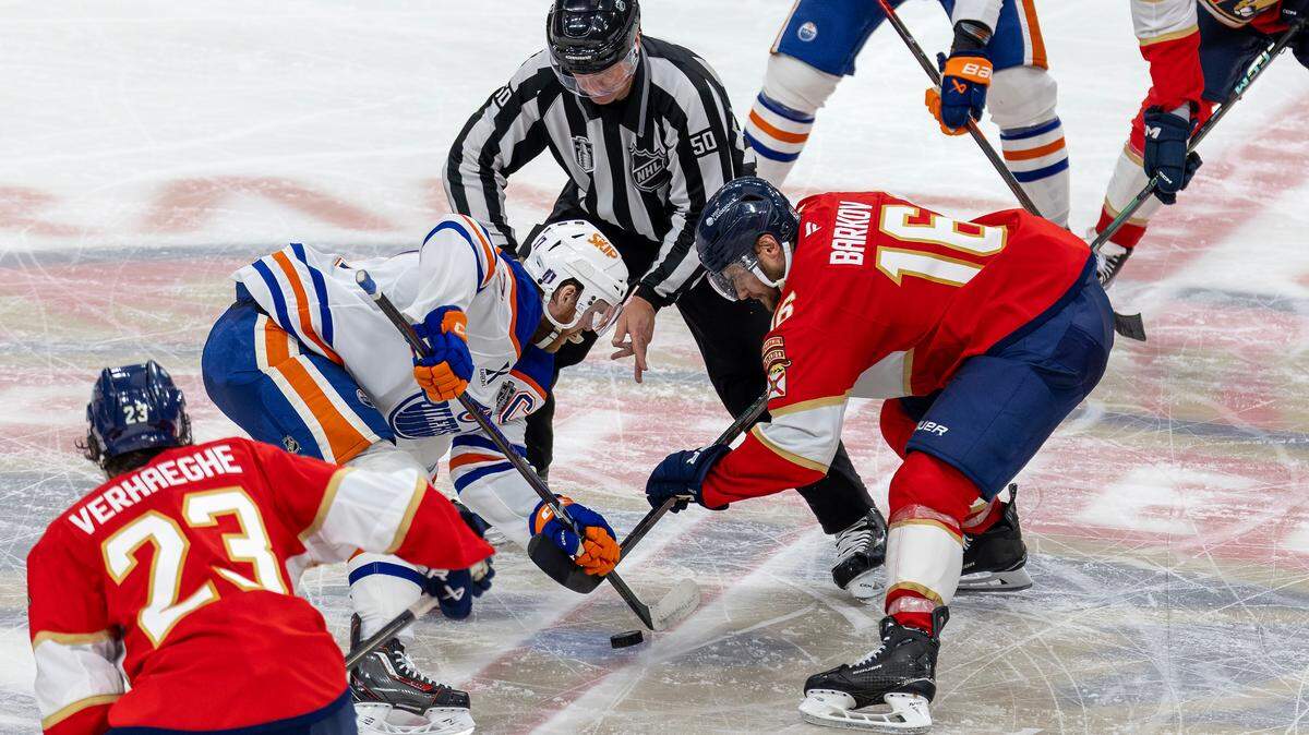 NHL linesman Scott Cherrey (50) drops the puck for a faceoff between Edmonton Oilers center Connor McDavid (97) and Florida Panthers center Aleksander Barkov (16) during the third period of Game 3 in the Stanley Cup Final at Amerant Bank Arena, Monday, June 9, 2025, in Sunrise, Fla.