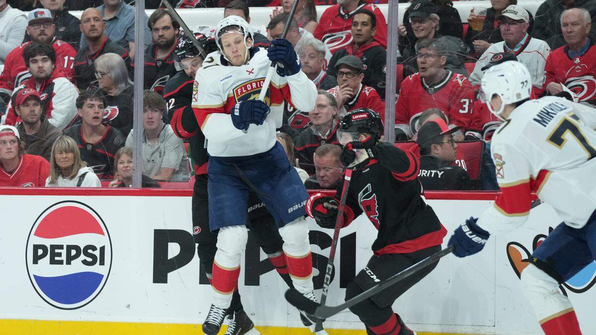 May 28, 2025; Raleigh, North Carolina, USA; Carolina Hurricanes forward Jesperi Kotkaniemi (82) checks Florida Panthers forward Eetu Luostarinen (27) during the first period in game five of the Eastern Conference Final of the 2025 Stanley Cup Playoffs at Lenovo Center.