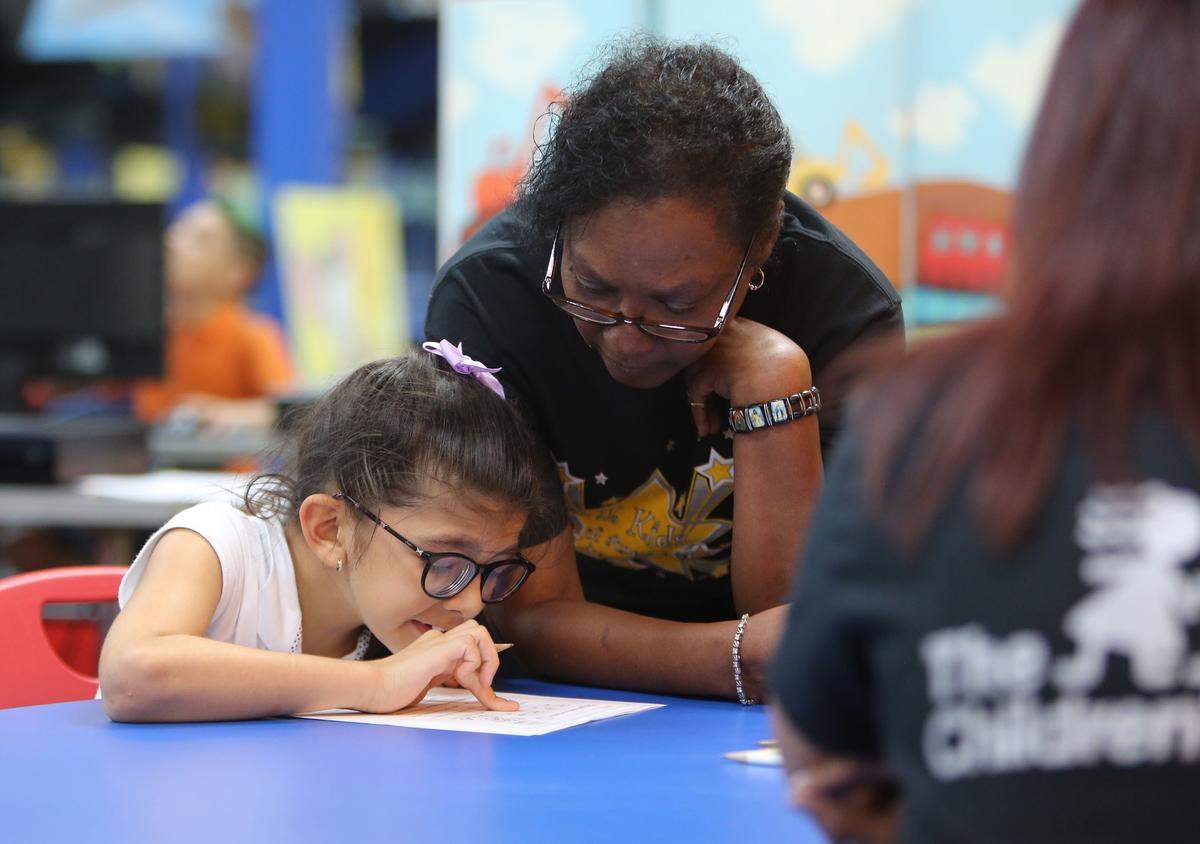 Fit Kids of America teacher Claire Worthy works with student Mayleen Castillo, 7, on word and math skills during an after-school program on Friday, Oct. 12, 2018.