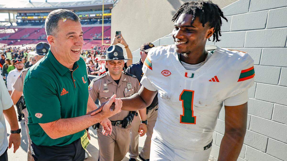 Miami Hurricanes head coach Mario Cristobal and quarterback Cam Ward (1) celebrate win against Louisville Cardinals after NCAA football game at L&N Federal Credit Union Stadium in Louisville, Kentucky on Saturday, October 19, 2024.
