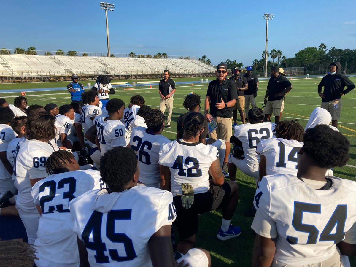 South Dade football coach Chris Reid speaks to his players after the Bucs beat Miami Killian 42-6 at Tropical Park on Monday afternoon.