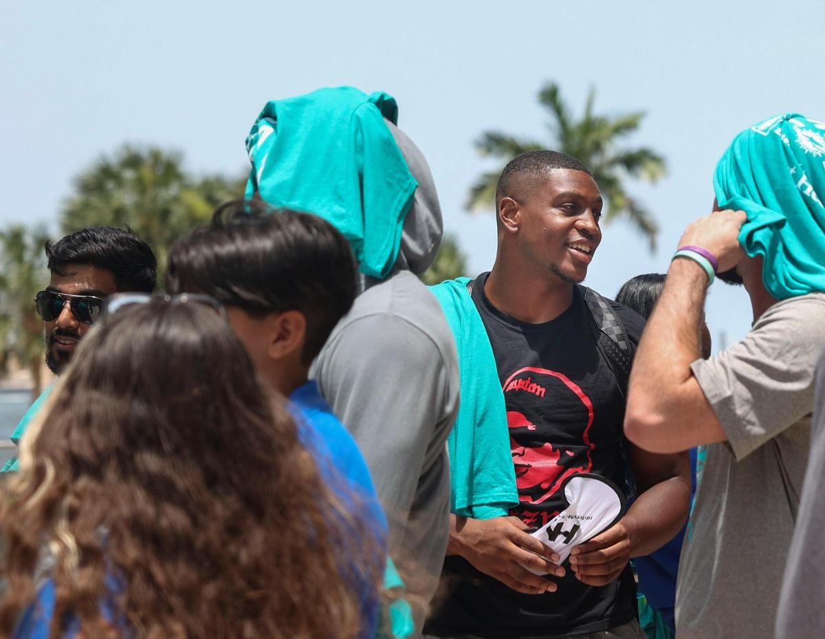 Channing Tindall, center, signed to the roster and member of the Miami Dolphins rookie class, participates in a historic walking tour of Downtown Miami with local community groups on Wednesday, June 15, 2022, beginning with tour leaders at the History Miami Museum. Tindall is one of four players of the rookie class actually signed to the roster for this coming season.