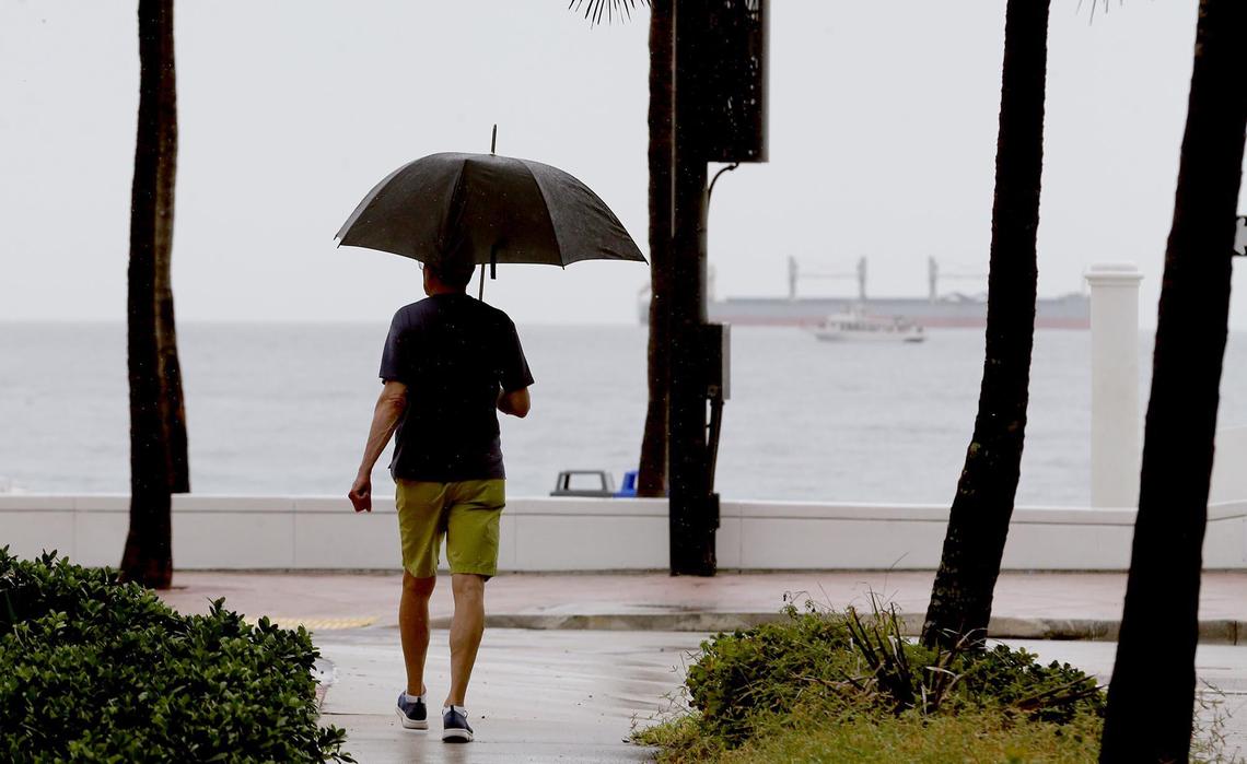 A man walks in the rain near Fort Lauderdale beach in Florida, June 14, 2021. Chance of precipitation was 70% Monday.