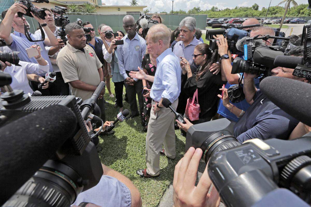 Senator Bill Nelson and Congresswoman Debbie Wasserman Schultz are denied access to the Homestead facility by a security officer, left, while surrounded by media.