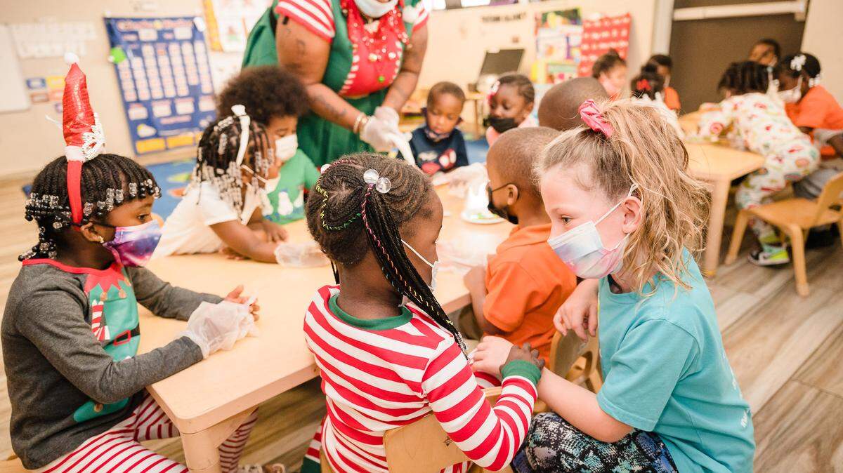 Genesis Medy and Layla Babicka share a moment of friendship at the Little Lighthouse Foundation’s 12th Annual Toy & Meal Distribution at Excel Kids Academy.