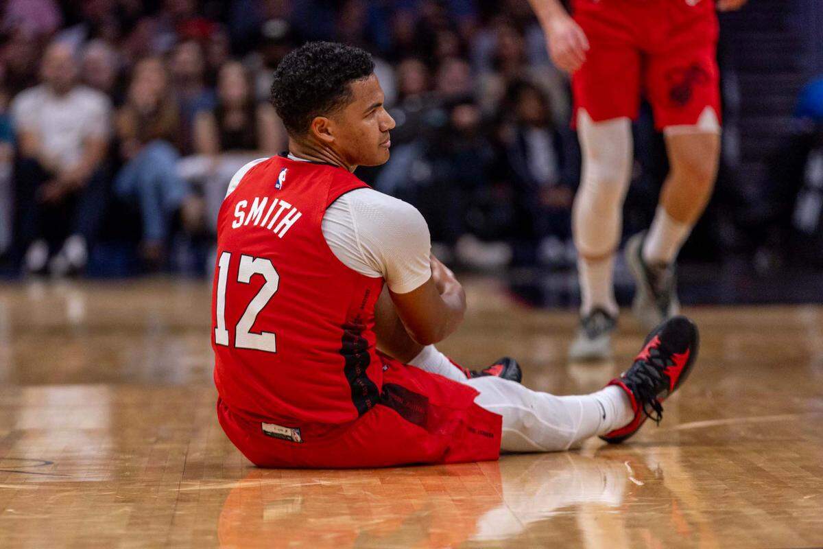 Miami Heat guard Dru Smith (12) grabs his leg after being injured on a play during the first half of an NBA game against the Brooklyn Nets at Kaseya Center on Dec. 23, 2024, in Miami.