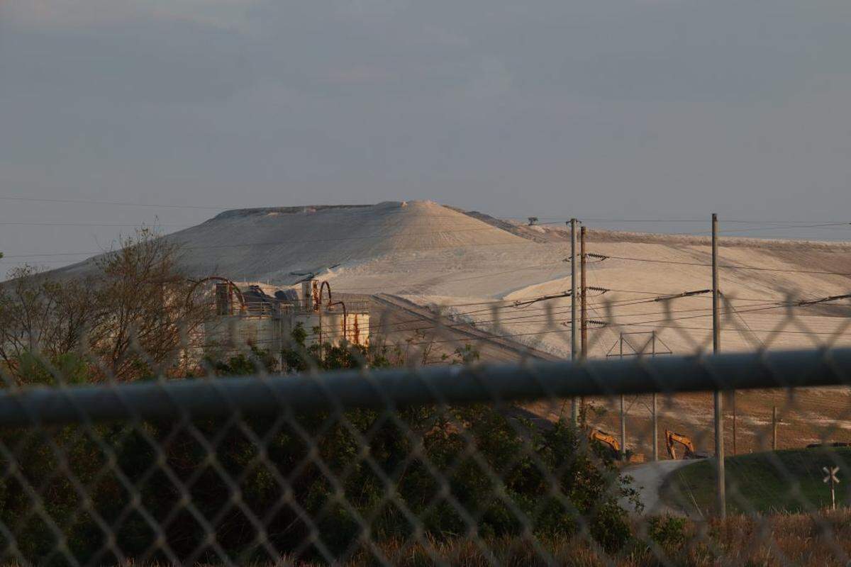 A phosphogypsum stack sits behind a fence in Bartow, Fla., Friday, Feb. 24, 2023.