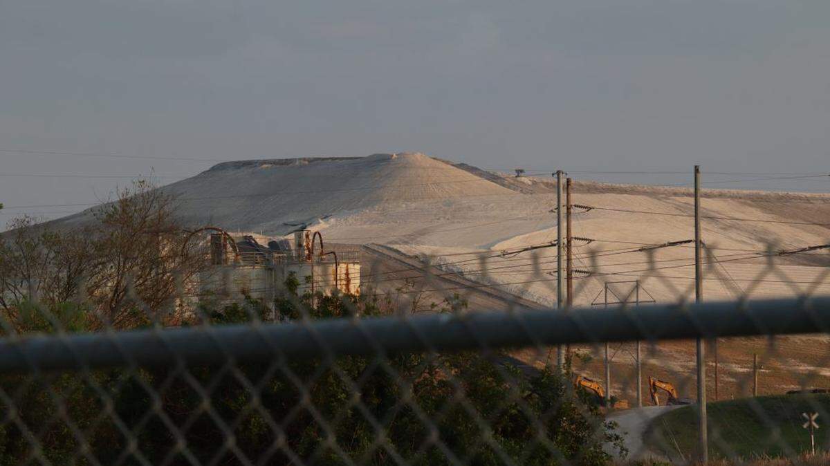 A phosphogypsum stack sits behind a fence in Bartow.. A bill approved Thursday by Florida Gov. Ron DeSantis clears the way to study the potential use of the toxic material in road construction,
