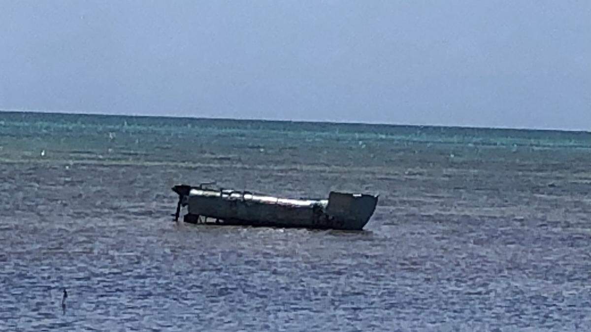 A homemade boat with a 2.5-horsepower outboard engine is grounded offshore of Long Key State Park in the Florida Keys Friday, March 18, 2022. The Border Patrol said 10 Cuban migrants were on the vessel.