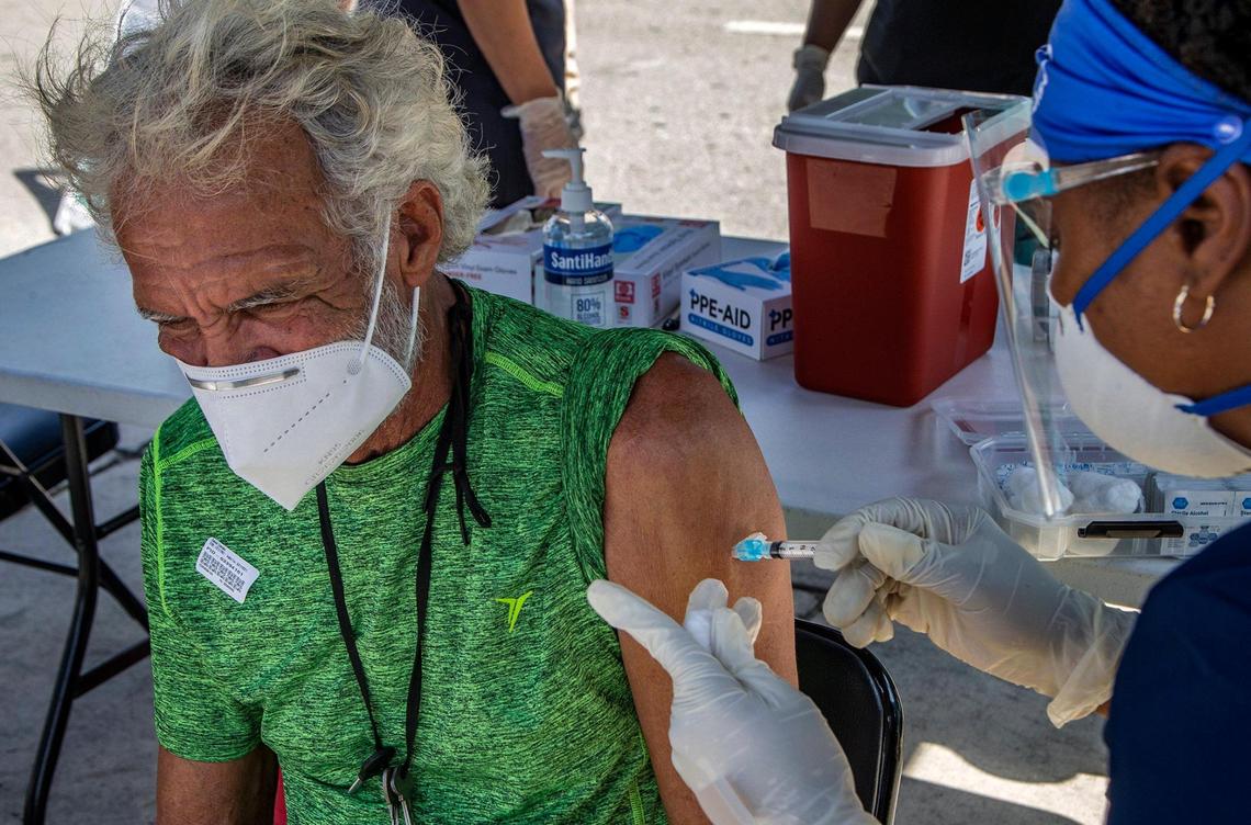 Nurse Saawana Plant gives a shot of the (J&J/Janssen) COVID-19 vaccine to Daniel Chaviano, a homeless man who is living under the I-95 underpass in downtown Miami, May 21, 2021.