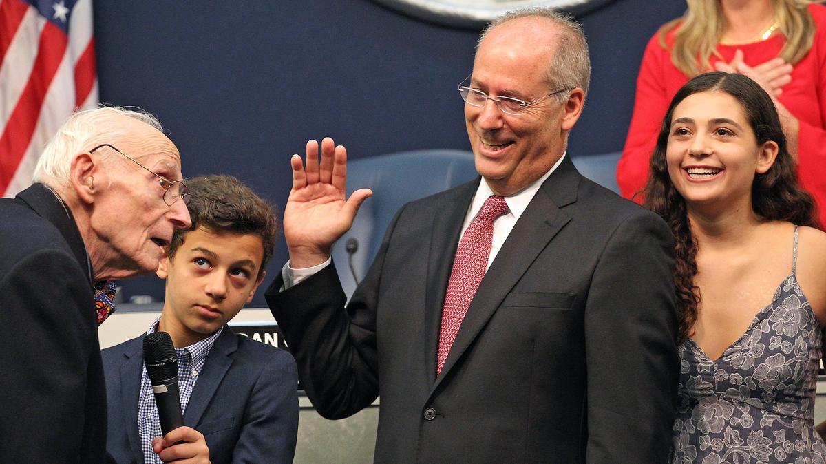 Dan Gelber, who would go on to serve three terms as Miami Beach mayor, is sworn in for his first term by his father, Seymour Gelber, who was also a three-term Miami Beach mayor. Watching the ceremony at City Hall on November 13, 2017, were two of Dan Gelber’s three children, Max, and Hannah.