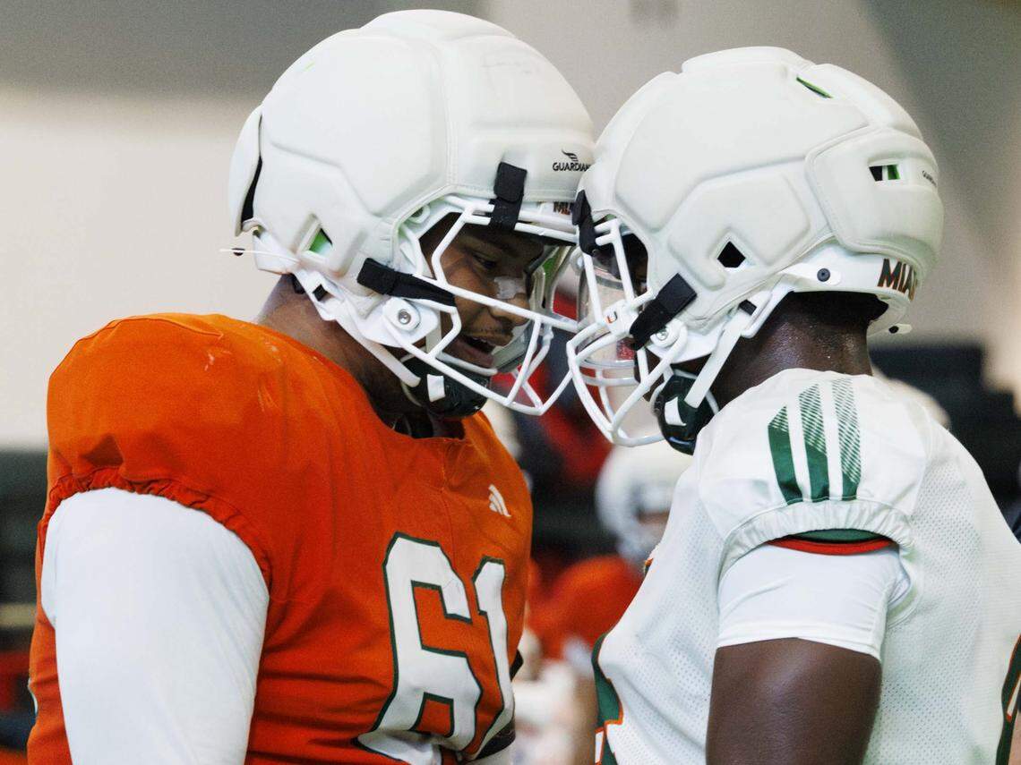 Offensive lineman Francis Mauigoa (61) and Defensive lineman Rueben Bain Jr. (4) touch helmets during Miami Hurricanes football practice on Monday, Aug. 4, 2025, at University of Miami in Coral Gables, Fla. 